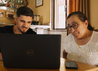 young person teaching elderly person how to use the internet