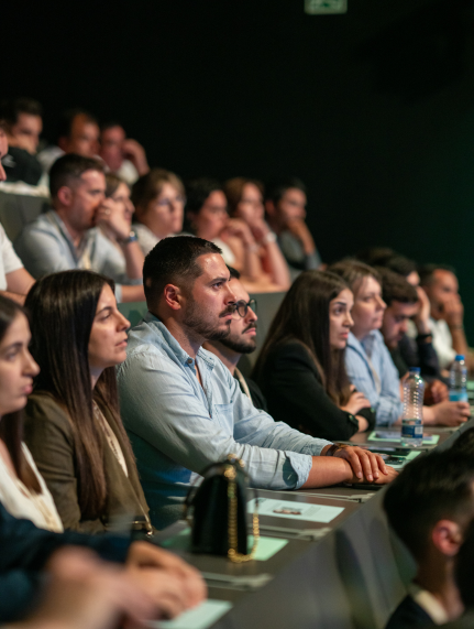 Pessoas sentadas num auditório, a assistir atentamente a uma apresentação